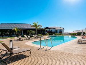 a pool with chaise lounge chairs and a table at Ocean's Edge Escape! in Ballito +19 photos
