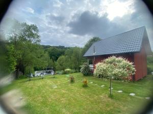 a red house with a yard with a yard at Domki że Hej Bieszczady in Ustrzyki Dolne