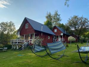 a house with a yard with chairs in front of it at Domki że Hej Bieszczady in Ustrzyki Dolne