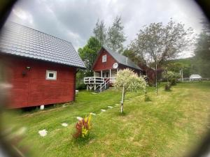 a red barn and a house with a yard at Domki że Hej Bieszczady in Ustrzyki Dolne +14 photos