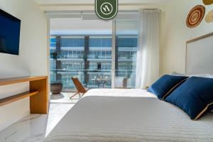 a bedroom with a large bed and a large window at 3BR Condo Right Next to the Beach - Pool - Palapa in Nuevo Vallarta +26 photos