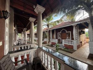 a view of a house with a balcony and palm trees at Baga Beach Palm Cottage in Calangute