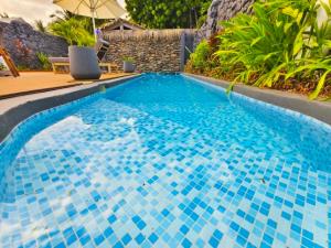 a swimming pool with blue tiles on it at Aitutaki Escape Resort & Spa in Arutanga
