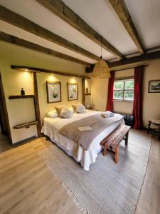 a large bedroom with a large bed and a bench at Casona el Refugio Casablanca in Casablanca