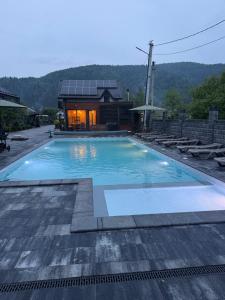 a large swimming pool in front of a house at Майя VIP in Mykulychyn