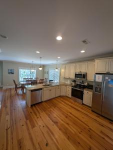 a large kitchen with wooden floors and stainless steel appliances at Sandnapper in Pawleys Island