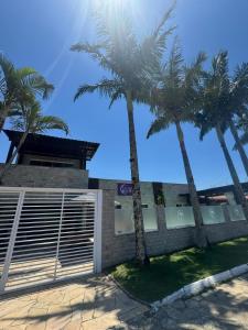two palm trees in front of a building with a garage at Suíte Monstros SA - Pousada Castelo do Luar in Penha