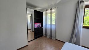 a living room with a television and a mirror at Fuga in Valpolcevera Comfort e Relax in Mignanego