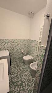 a bathroom with a toilet and a green and white tiles at Fuga in Valpolcevera Comfort e Relax in Mignanego +17 photos