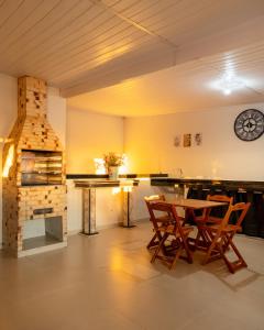 a room with a table and chairs and a fireplace at Souza Apart 1 - Apartamentos completos com muito aconchego in São Thomé das Letras