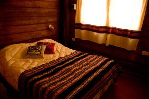 uma pequena cama num quarto com uma janela em Finca La Colorada em San Salvador de Jujuy
