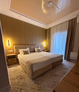 a bedroom with a large bed and a large window at Tinchlik Plaza in Urganch +16 photos