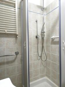 a bathroom with a shower with a glass door at Alloggio turistico borgo antico in Bagnaia