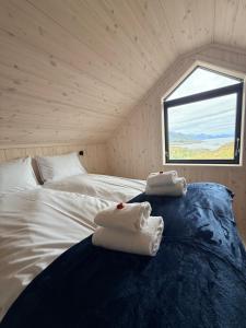 a bedroom with a bed with towels on it at Chalet Glåpen in Moskenes