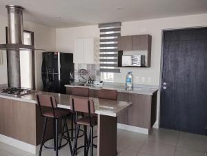 a kitchen with a counter and bar stools in it at Catalán Sant Andreu in Guadalajara
