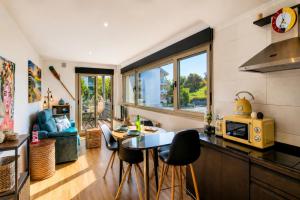a kitchen and living room with a table and chairs at Las Xanas · Vistas, Piscina y Terraza en LLanes in Llanes