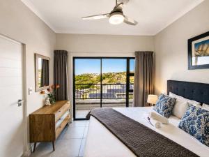 a bedroom with a large bed and a balcony at Ocean Sunrise! in Ballito