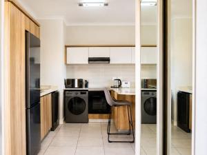 a kitchen with black appliances and a chair in it at Ocean Sunrise! in Ballito