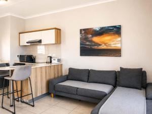 a living room with a couch and a kitchen at Ocean Sunrise! in Ballito +8 photos
