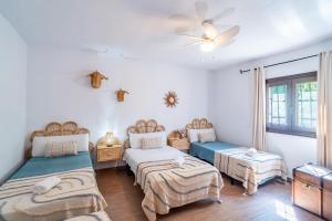a bedroom with two beds and a window at La Encina in Lanjarón +34 photos