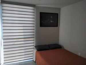 a bedroom with a bed and a window with blinds at Catalán Sant Andreu in Guadalajara