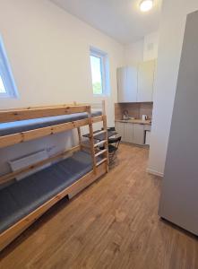 a room with two bunk beds and a kitchen at Mini nocleg przy dworcu in Tomaszów Mazowiecki