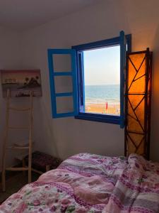 a bedroom with a window with a view of the beach at Soft Sand Beach in Taghazout +16 photos
