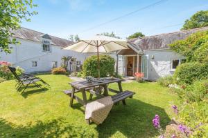 a picnic table with an umbrella in a yard at 1 Bed in Falmouth oc-85594 in Constantine
