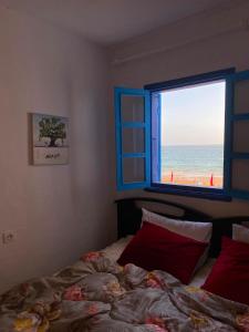 a bedroom with a bed and a window with a beach at Soft Sand Beach in Taghazout