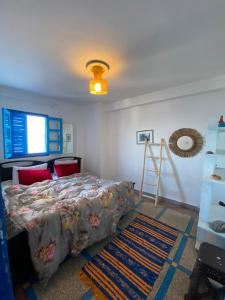 a bedroom with a bed and a light on the ceiling at Soft Sand Beach in Taghazout