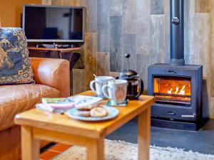 a living room with a fireplace and a table with food at 2 Bed in Minehead oc-77362 in Withypool