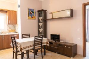 a dining room with a table and chairs and a television at Joy & Grace Apartments Ksamil in Ksamil +41 photos