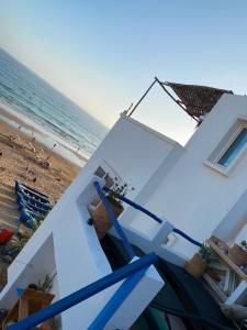 a white house on the beach with the ocean at Soft Sand Beach in Taghazout