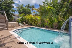 a swimming pool with a fountain in a yard at Colors on White in Key West