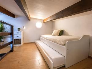 a small bedroom with a bed and a mirror at Chez Fifi in Surpierre