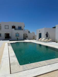 a villa with a swimming pool and a house at Les jardins de Sara in Mellita