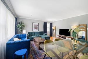 a living room with a blue couch and a table at Retro 3BR Walkup Apt and Shared Yard and Parking in Yonkers