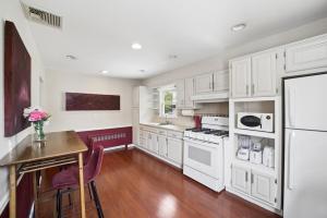 a kitchen with white appliances and a wooden table at Retro 3BR Walkup Apt and Shared Yard and Parking in Yonkers