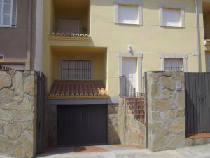 un edificio con dos puertas de garaje y una pared de piedra en Apartamento Villa Soterraña, en Trujillo