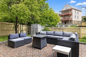 a patio with a couch and chairs and a table at Retro 3BR Walkup Apt and Shared Yard and Parking in Yonkers
