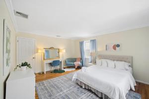 a white bedroom with a bed and a television at Retro 3BR Walkup Apt and Shared Yard and Parking in Yonkers