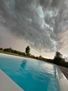 a blue swimming pool under a cloudy sky at Emville in Vysshaya Dubechnya +12 photos