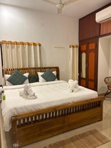 a bedroom with a large bed with towels on it at L'EDELWEISS Heritage House in Pondicherry
