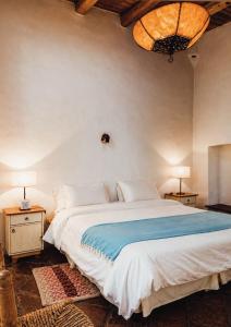 a bedroom with a large bed with a blue blanket at Hosteria Villa Cardon in Cachí
