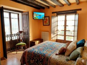 a bedroom with a bed in a room with windows at Posada Campo in Suances