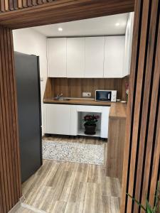 a kitchen with white cabinets and a sink and a refrigerator at Casa Andora Brașov in Braşov