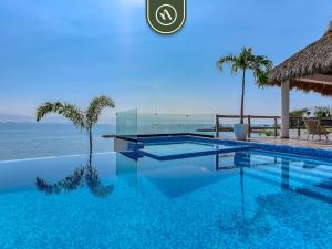 a swimming pool with a view of the ocean at Luxury Oceanfront 3 BR Condo with Balcony in Cruz de Huanacaxtle