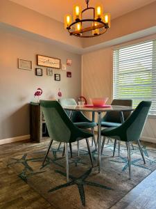 a dining room with a table and green chairs at Coastal Bungalows--The Flamingo Bungalow in Fort Lauderdale