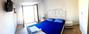 a small bedroom with a blue bed and a window at Apartments Bašić Pirovac - Sea view - Small and large groups in Pirovac