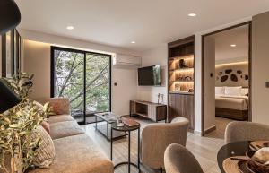 a living room with a couch and a bed at Casa Grijalva by Kukun Apartments in Mexico City